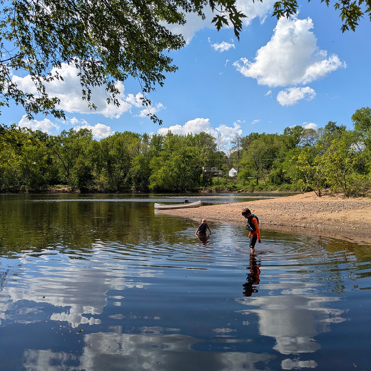 Two children wade in a peaceful bit of the Chippewa River at Bean Island, Eau Claire, Wisconsin.